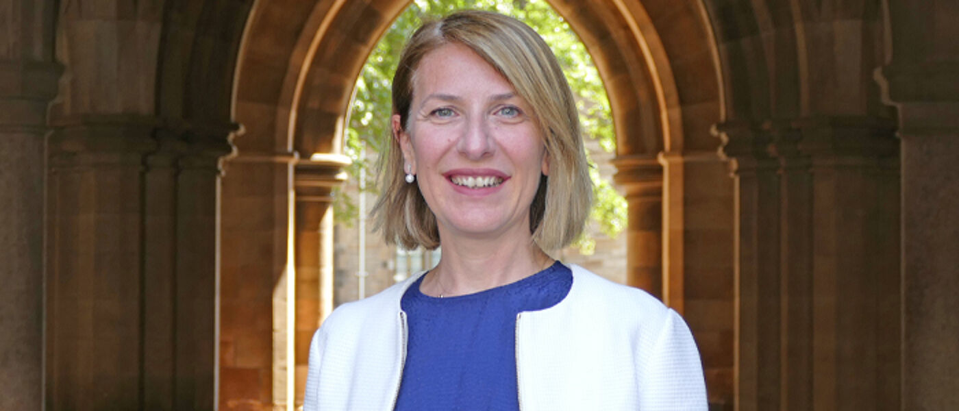 Professor Nuran Acur underneath an archway in the cloisters
