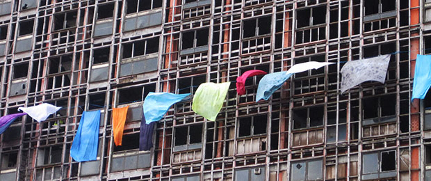 sheets hanging out of windows on a high rise flat