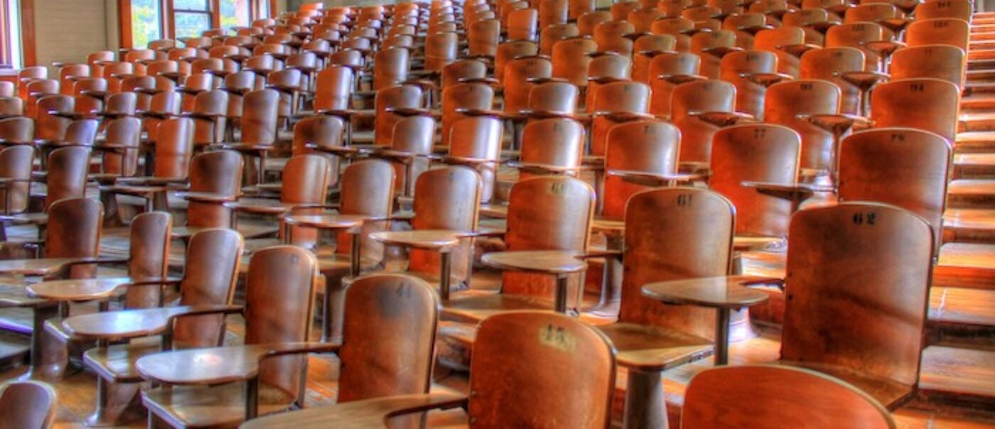 Empty lecture hall with wooden seats